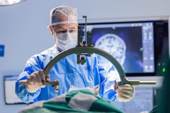 Médico do Hospital Moinhos de Vento realiza procedimento cirúrgico utilizando equipamento avançado em centro cirúrgico.