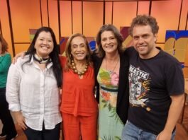 Foto de Lara Velho no estúdio do programa Sem Censura, sentada ao lado de Cissa Guimarães durante entrevista ao vivo.