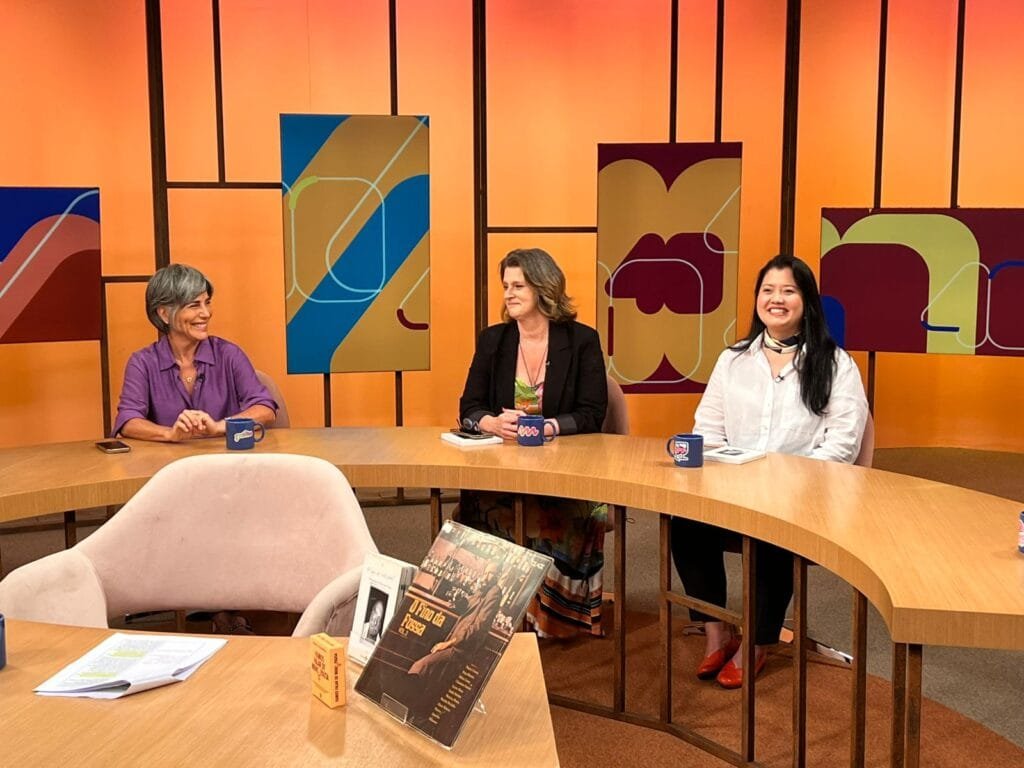 Imagem das convidadas do Sem Censura — Lara Velho, Gloria Pires e Mírian Goldenberg — conversando no estúdio da TV Brasil sobre a exposição em homenagem a Peréio.