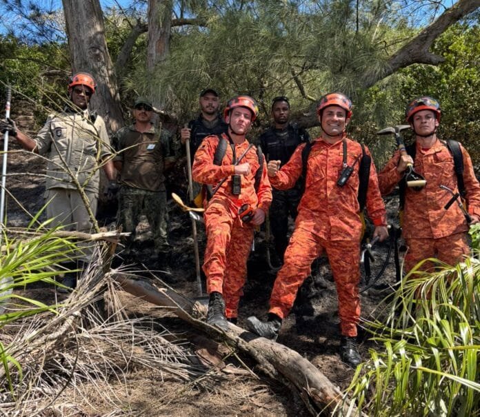 Agentes da Guarda Marítima e Ambiental e equipes de apoio posam em área de vegetação atingida por princípio de incêndio na região da Praia do Peró, em Cabo Frio, após controlarem as chamas.