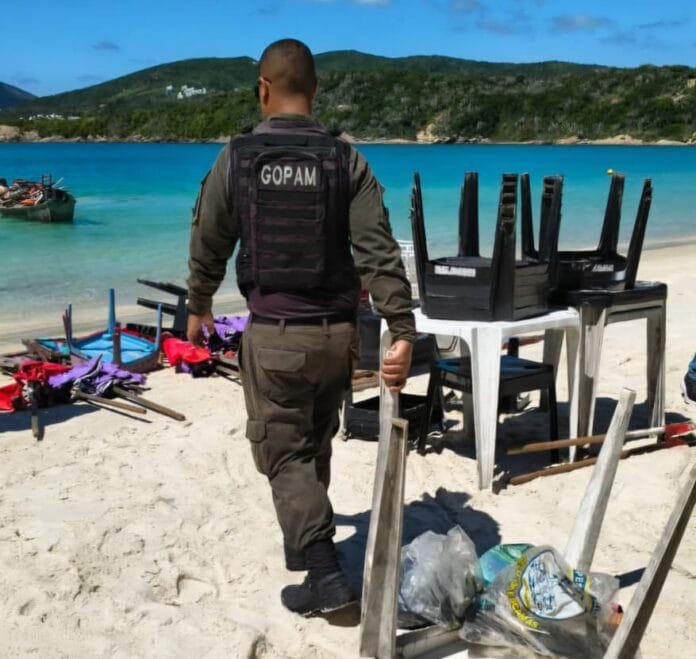 Agentes da Prefeitura removendo cadeiras e equipamentos de praia armazenados irregularmente na areia da Praia do Forno.