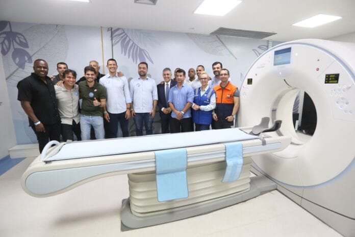 Rio Imagem Lagos em Casimiro de Abreu 5 Autoridades reunidas durante a inauguração de um centro de diagnóstico por imagem, ao lado de um tomógrafo moderno em ambiente hospitalar.