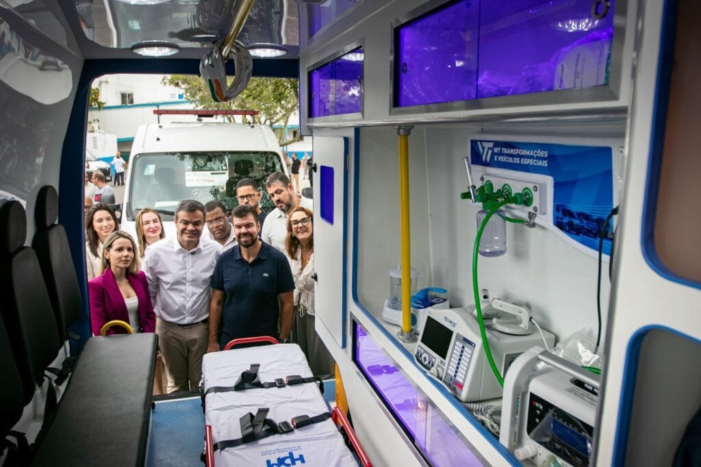 Prefeito e Dr. Lucas observam e vistoriam ambulâncias novas estacionadas, durante evento oficial de entrega.