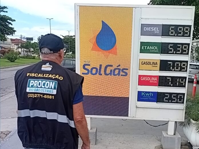 Fiscais analisam tabela de valores exposta ao consumidor durante ação de fiscalização no município.