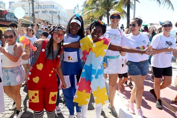 Foto de crianças e adultos sorrindo participando de caminha pelo autismo da promovida pela prefeitura de Macaé RJ