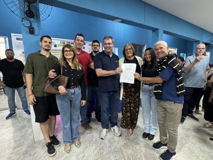 Foto de autorudades sorrindo e segurando documento referente aos investimentos