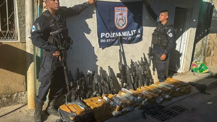 Foto de policiais militares apresentando as armas e drogas apreendidas no complexo camará zona oeste do Rio
