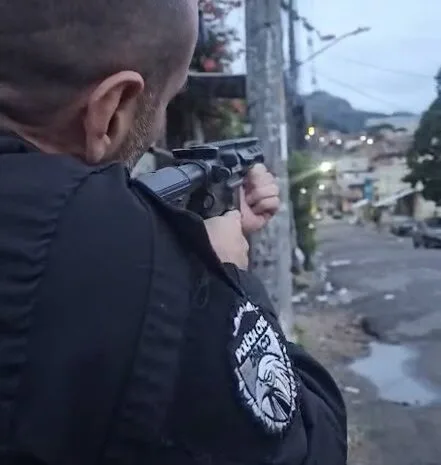 Foto de um policial com arma em ação de captura de crimisosos