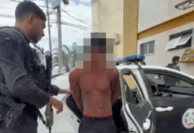 Suspeito com histórico no tráfico de drogas foi localizado no bairro Nova Holanda após trabalho de inteligência Foto do homem sem camisa e de chinelo preso pela policia civil saindo do carro da delegacia 123 dp