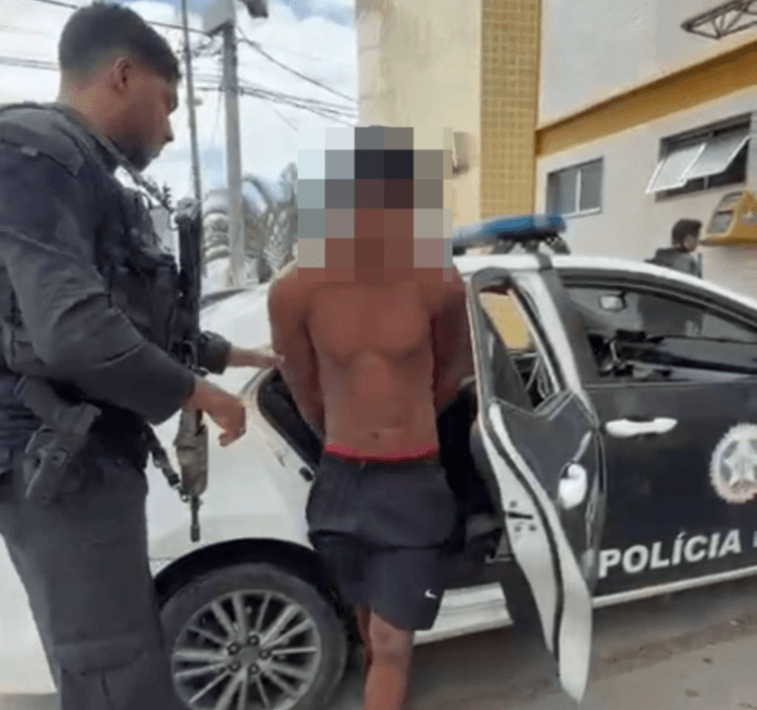 Foto do homem sem camisa e de chinelo preso pela policia civil saindo do carro da delegacia 123 dp