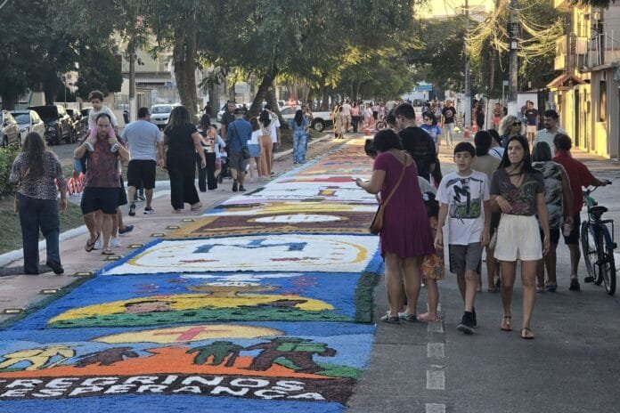 Foto de pessoas fazendo tapetes coloridos nas ruas de Macaé para o feriado de Corpus Chrsti