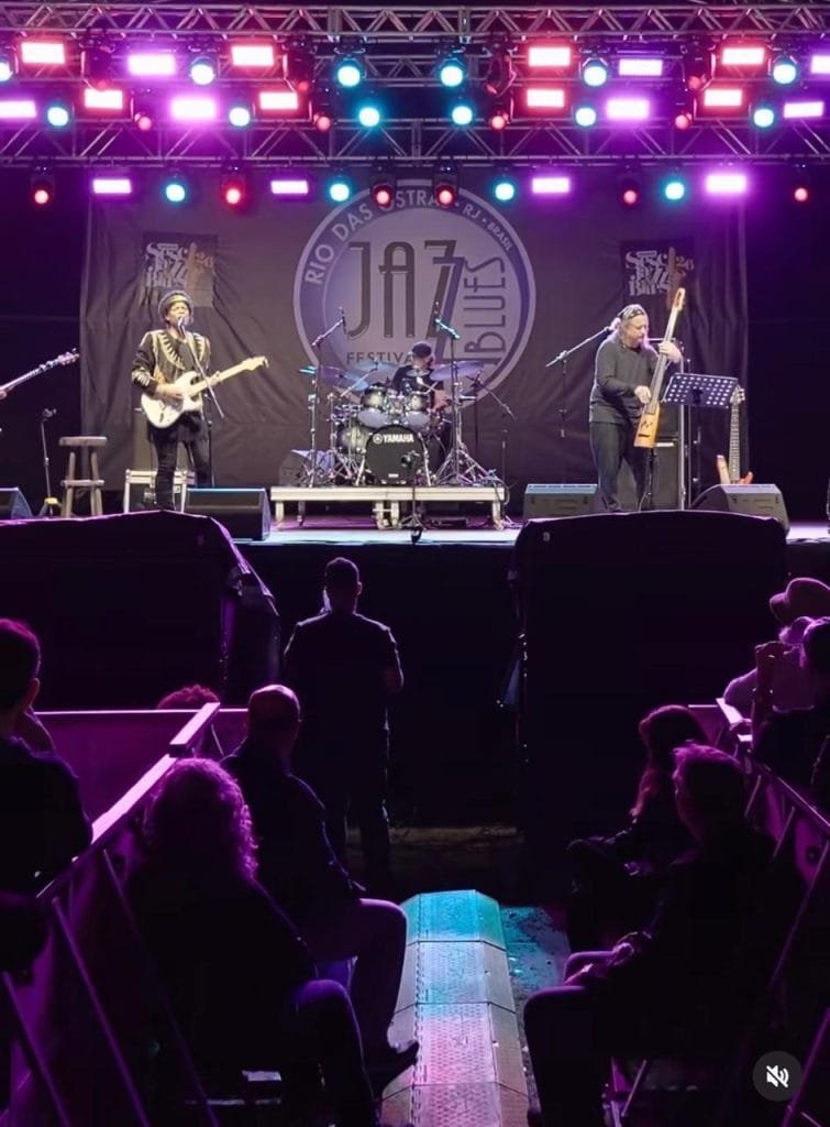 Foto do palco com show de uma banda no festival